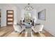 Bright, well-lit living room featuring hardwood floors, white walls, a modern light fixture, and neutral furniture at 4329 Lambeth Dr, Raleigh, NC 27609