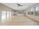 Bright living room with light hardwood floors, ceiling fan, large windows, and built-in TV console at 4329 Lambeth Dr, Raleigh, NC 27609