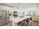 Bright, open kitchen with stainless steel appliances, white cabinets, and a large center island with bar seating at 683 Mirkwood, Apex, NC 27523