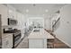 Spacious kitchen flows into the living area, featuring a large island with seating and stainless steel appliances at 683 Mirkwood, Apex, NC 27523