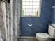 Bathroom featuring blue textured walls, patterned shower curtain, and a toilet at 711 Weathervane Way, Rocky Mount, NC 27803