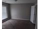 Carpeted bedroom with natural light from a window and a neutral color scheme at 711 Weathervane Way, Rocky Mount, NC 27803
