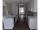 Open concept kitchen featuring wood floors, white cabinets, and modern appliances at 711 Weathervane Way, Rocky Mount, NC 27803
