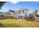 Wide shot of the backyard featuring a large, green lawn and a covered patio with outdoor dining at 1005 Forest Willow Ln, Morrisville, NC 27560