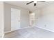 Neutral bedroom featuring plush carpeting, a ceiling fan, and a paneled door at 101 Rock River Rd, Morrisville, NC 27560