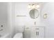 Bathroom features stylish gold fixtures, round mirror, and white tile and vanity at 1011 Lowry Ave, Durham, NC 27701