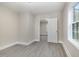 Neutrally painted bedroom with new gray floors and a view to the next room at 1012 E Harnett St, Dunn, NC 28334