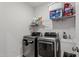 Bright laundry room with modern washer, dryer, and storage shelving at 1014 Falling Rock Pl, Durham, NC 27703