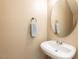 Powder room with pedestal sink and round decorative mirror at 102 Forrymast Trl, Apex, NC 27539
