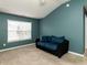 Cozy carpeted bedroom with a window providing natural light and comfortable seating with a love seat at 102 Forrymast Trl, Apex, NC 27539