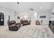 Spacious living area featuring brown leather couches, ceiling fans, and a patterned area rug at 1105 Lowland St, Apex, NC 27523