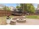 Inviting backyard featuring a fire pit, trampoline, and stone-lined flower beds for outdoor enjoyment at 1117 Golden Star Way, Wake Forest, NC 27587