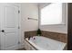 A soaking tub beneath a window with tiled walls and bronze fixtures at 1117 Golden Star Way, Wake Forest, NC 27587