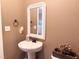 Powder room featuring pedestal sink, decorative mirror, and neutral tones at 1117 Golden Star Way, Wake Forest, NC 27587