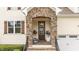 Inviting front porch with stone archway, plants, and a cozy 'Home Sweet Home' door decoration at 1117 Golden Star Way, Wake Forest, NC 27587