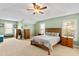 Spacious main bedroom featuring tray ceilings, ceiling fan, and neutral carpeting at 1122 Virginia Water Dr, Rolesville, NC 27571