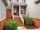 Inviting front porch with brick steps, white railing, and vibrant landscaping at 1213 Red Beech Ct, Raleigh, NC 27614