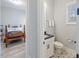 Powder room with star pattern floor tiles and single sink vanity, adjacent bedroom at 1421 Sweetclover Dr, Wake Forest, NC 27587