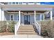 Welcoming front porch with brick stairs, black double doors, and a cozy seating area at 1421 Sweetclover Dr, Wake Forest, NC 27587