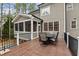 Spacious deck with black railings and table and chairs next to screened-in porch at 160 Rivers Edge Dr, Youngsville, NC 27596