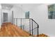 Bright hallway with wood floors, modern railing, and natural light from nearby windows at 168 Daphine Dr, Hillsborough, NC 27278