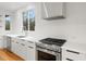 Bright kitchen with stainless steel appliances, white cabinets, and a stainless vent hood at 168 Daphine Dr, Hillsborough, NC 27278