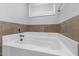 Bathroom featuring soaking tub, tile accents, and sleek chrome faucet at 176 E Ravano Dr, Clayton, NC 27527