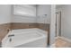 Relaxing bathroom with a soaking tub, tile accents, and a window for natural light at 176 E Ravano Dr, Clayton, NC 27527
