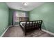 Cozy bedroom featuring carpeted floors, a large window, and a dark wood bed frame at 176 E Ravano Dr, Clayton, NC 27527