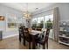 Bright dining room with a stylish chandelier and a view of the fenced-in backyard through large windows at 176 E Ravano Dr, Clayton, NC 27527
