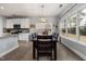 Well-lit dining area featuring a wooden table, seating for six, and large windows overlooking the backyard at 176 E Ravano Dr, Clayton, NC 27527
