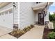 Home's front entry features a decorative front door, sidelight, landscaping, and sideload garage at 176 E Ravano Dr, Clayton, NC 27527