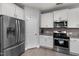 Modern kitchen with stainless steel appliances, white cabinetry, and a view into the dining area at 176 E Ravano Dr, Clayton, NC 27527