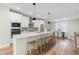 Bright kitchen featuring white cabinets, stainless steel appliances, an island with seating, and hardwood floors at 1858 Fahey Dr, Apex, NC 27502