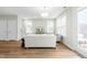 Bright living room with wood floors, two windows, and a glass door leading to a deck at 1858 Fahey Dr, Apex, NC 27502