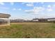 Wide shot of a fenced back yard with partially green lawn, and covered patio in the distance at 229 S Prince Henry Way Way, Cameron, NC 28326