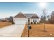 Charming single-Gathering home with attached two-car garage, paved driveway, and manicured lawn on a sunny day at 229 S Prince Henry Way Way, Cameron, NC 28326