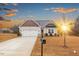 Inviting single-Gathering home with an attached garage, a paved driveway, and a manicured lawn at sunset at 229 S Prince Henry Way Way, Cameron, NC 28326