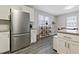 Modern kitchen featuring stainless steel refrigerator, white cabinetry, granite countertops, and stylish gray flooring at 2305 Fitzgerald Ave, Durham, NC 27707