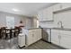 Bright kitchen with white cabinets, granite countertops, stainless steel appliances, and a dining table in the background at 2305 Fitzgerald Ave, Durham, NC 27707
