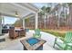 Inviting covered porch with a dining table, fan, and a fire pit with Adirondack chairs at 240 Forest Meadow Ln, Franklinton, NC 27525
