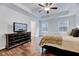 Bright bedroom featuring two windows, recessed ceiling, and wood look floors with a television at 240 Forest Meadow Ln, Franklinton, NC 27525