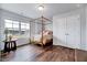 A sunlit bedroom showcases a cozy four-poster bed with wood floors near a large window and closet at 240 Forest Meadow Ln, Franklinton, NC 27525