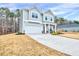 Two-story gray home featuring a two-car garage, pristine landscaping, and a long driveway at 240 Forest Meadow Ln, Franklinton, NC 27525