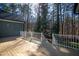 Lovely wooden back deck with white railings offering serene views of the wooded backyard at 2713 Penfold Ln, Wake Forest, NC 27587