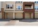Condo exterior featuring tan siding, brick accents, and attached garages; a comfortable and convenient place to call home at 2810 Bedford Green Dr # 300, Raleigh, NC 27604