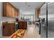 Well-lit kitchen with stainless steel appliances, brown cabinetry, and a view of the adjacent dining room and Gathering area at 2810 Bedford Green Dr # 300, Raleigh, NC 27604