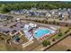 Aerial view of neighborhood pool featuring sun loungers, shaded seating, and clubhouse at 2981 Thurman Dairy Loop, Wake Forest, NC 27587