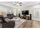 Bright living room with large windows, hardwood floors, comfortable seating, and modern entertainment center at 2981 Thurman Dairy Loop, Wake Forest, NC 27587