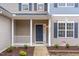 Inviting front porch with white columns and a cozy entrance, enhanced by landscaped garden beds at 3020 Buttonwood Ln, Clayton, NC 27520